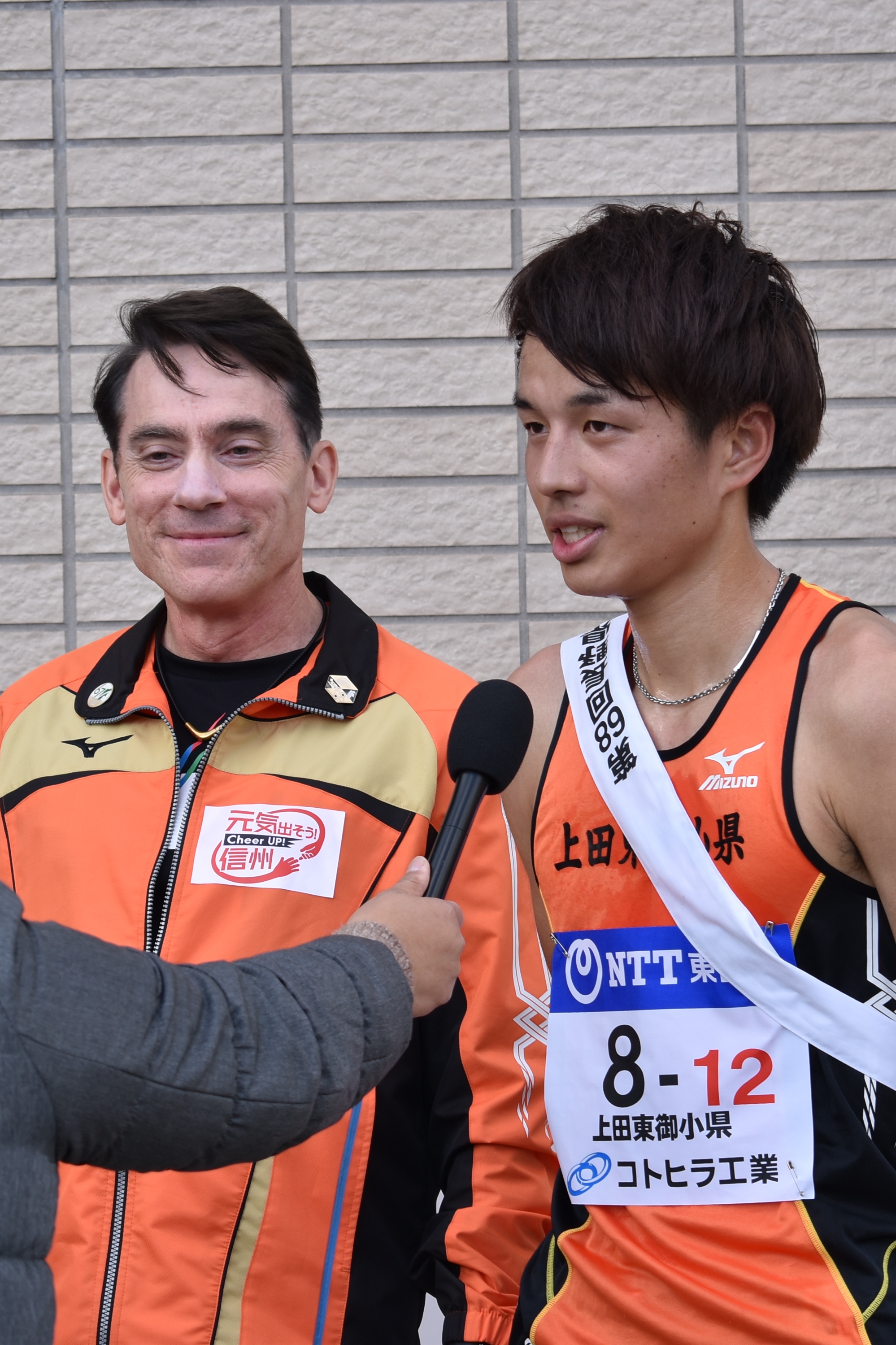 インタビューを受けるビル・レッティ監督と永井慎也選手の写真